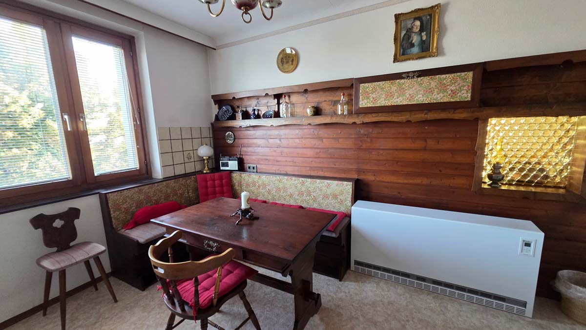 Küche: Eckbank mit Holztisch und Durchreiche